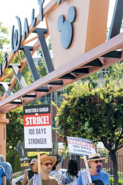 Members of the Writers Guild of America hold signs at a picket line outside of Disney Studio, in Burbank, California