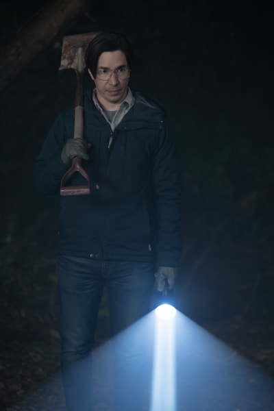 Pratt holds a flashlight and shovel in the dark