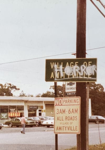 Defaced Amityville Sign