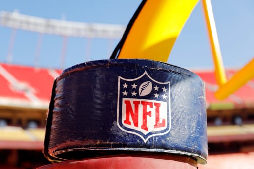 A detail view of the NATIONAL FOOTBALL LEAGUE logo on the goal post 